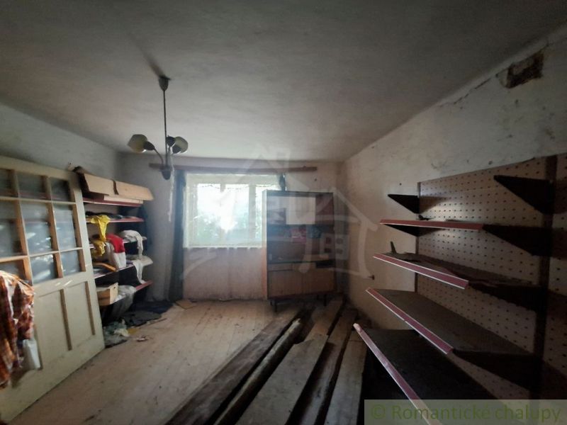 An unkempt room in a family house with wooden shelves and racks.