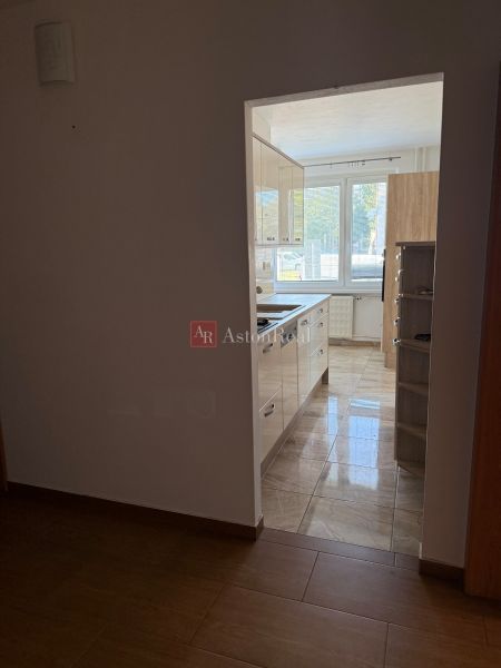 A view from a 3-room apartment to the kitchen with a tiled floor.