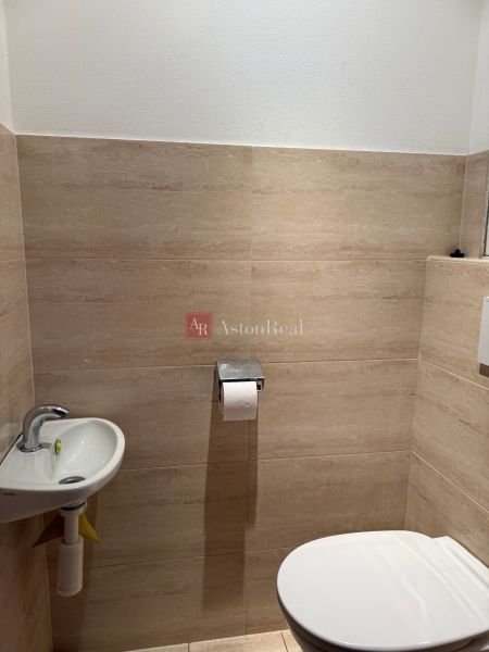 A bathroom in a 3-room apartment with beige tiles and a compact sink.