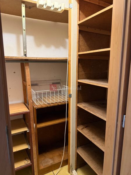Storage space with shelves and a wire basket in a 3-room apartment.