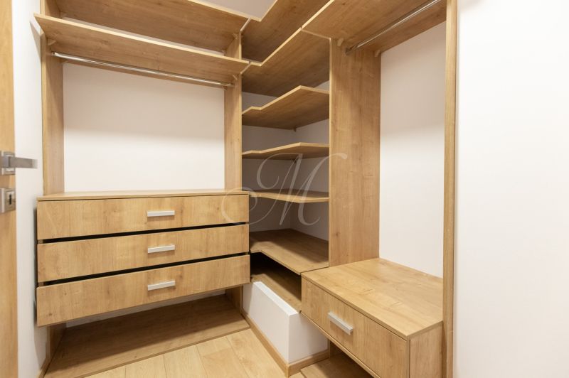 A wardrobe with shelves and drawers made of wood in a 4-room apartment.