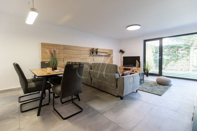 Living room in a 4-room apartment with large windows and comfortable seating furniture.