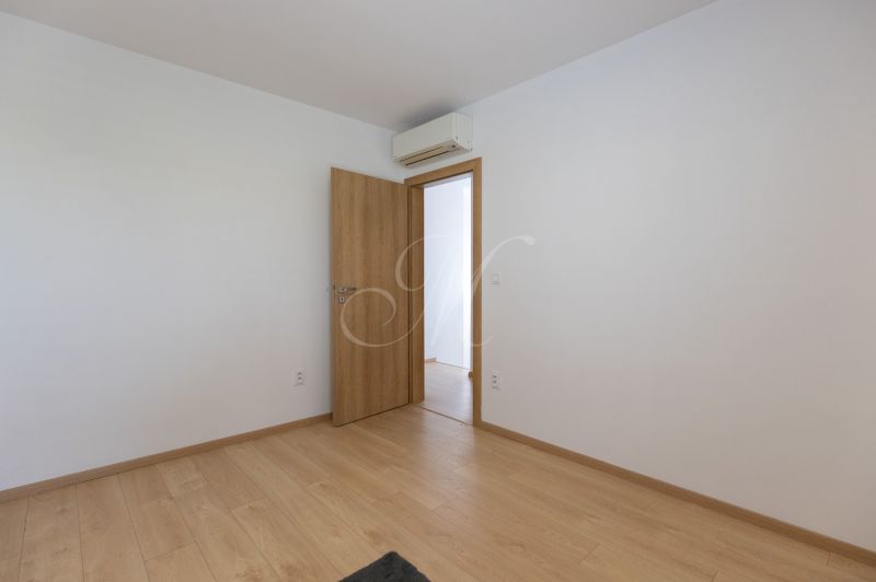 A room in a 4-room apartment with a wooden decor floor and air conditioning.