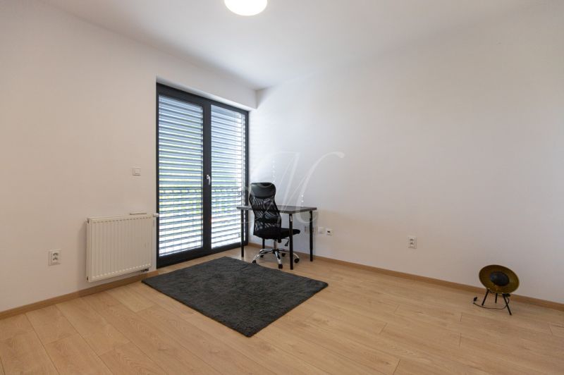 A workspace with a desk and chair in a 4-room apartment, flooring with a wood decor.