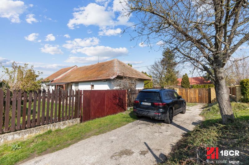 A family house on Legionárska in Mani with a yard and a black SUV by the gate.