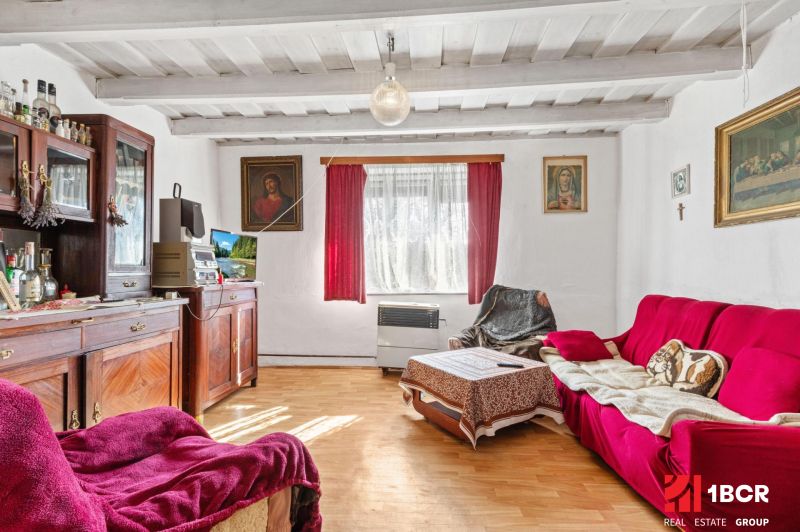 Living room in a family house with a wooden decor floor and red seating.