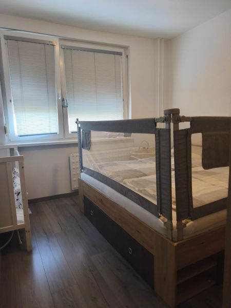 Children's room with a bed, barrier, and floor with wooden decor in a 3-room apartment.