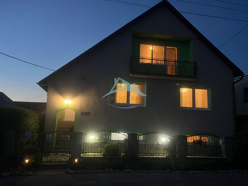 A family house on Tešmak Street in Šahy with glowing windows during the evening.
