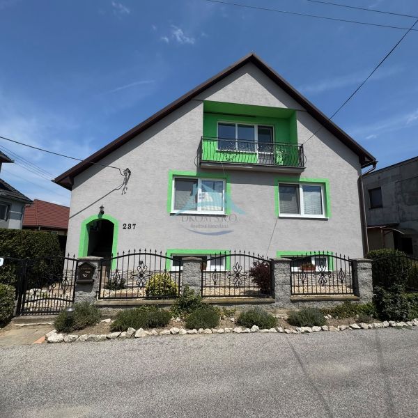 A family house on Tešmak Street in Šahy with green shutters and a balcony.