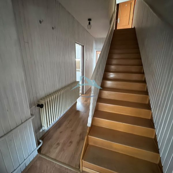 Interior of a family house with a wooden staircase and a floor with a wood decor.