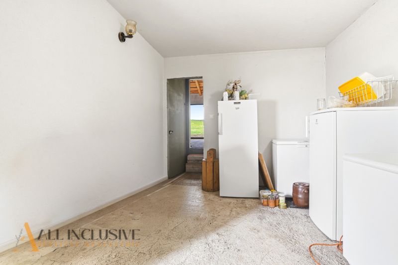 Storage space in a family house with refrigerators and shelves, floor with wooden decor.