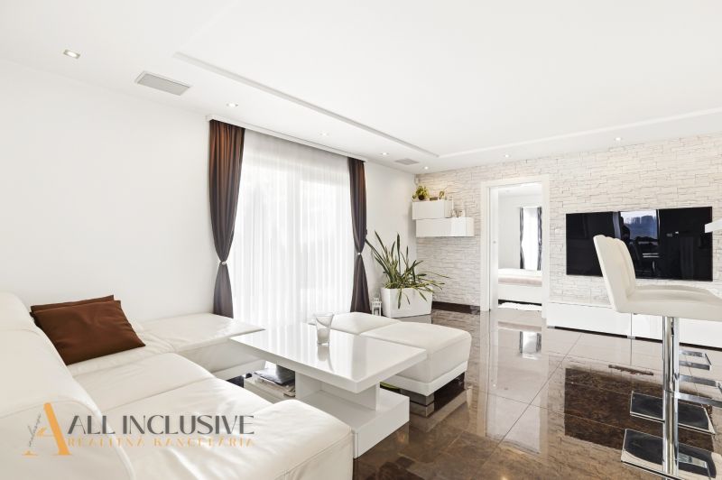 A living room of a family house with soft lighting, a wooden decor floor, light seating.