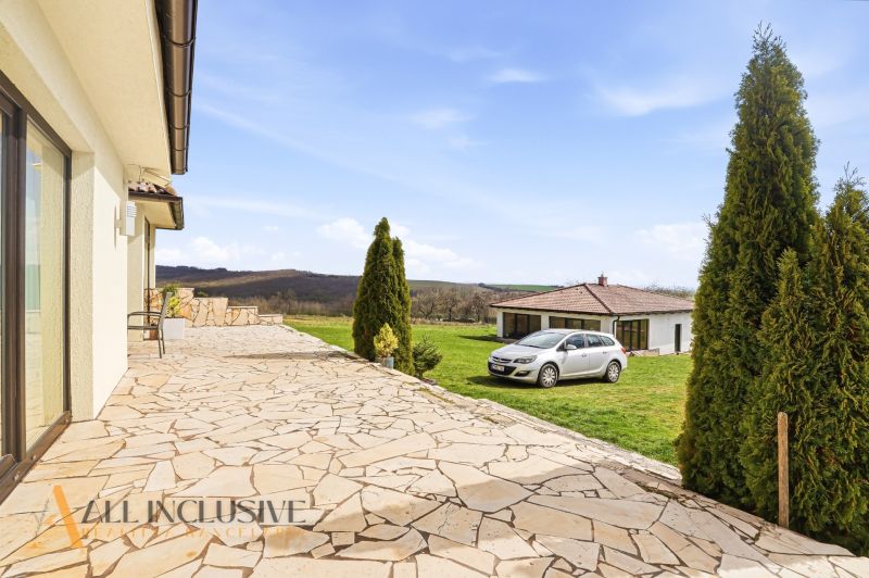 A garden terrace by a family house in Kopanice in Krupina with a view and a parked car.