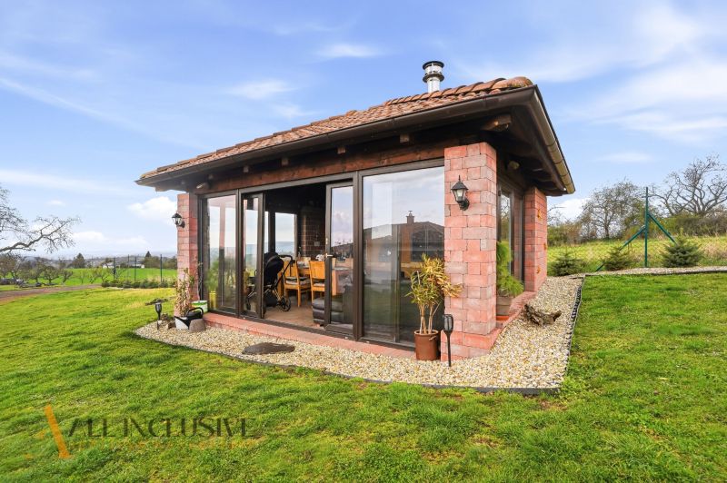 A family house on Kopanice Street in Krupina, with a glass wall and a landscaped garden.