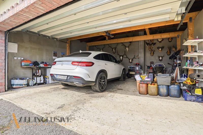 The garage of a family house in Kopanice, Krupina with a white car and trophies.