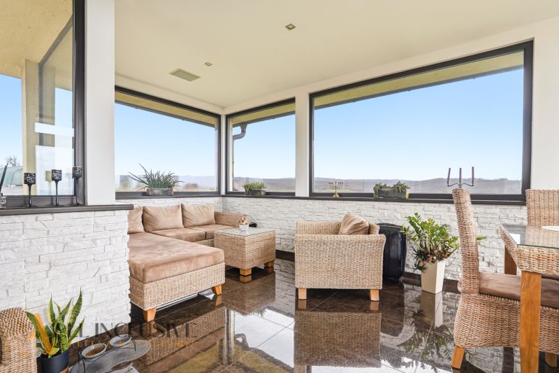 Windows and wicker furniture in a family house, wooden decor flooring, view of the countryside.