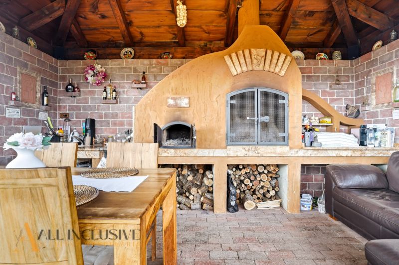 A fireplace with brick cladding and wooden decor in a family house, interior with seating area.