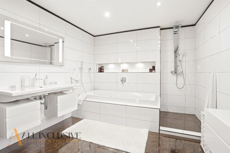 Modern bathroom with a bathtub, shower, and wood-patterned flooring in a family house.