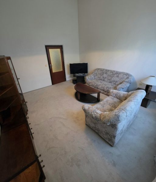 Living room with a sofa, table, and television in a three-room apartment.