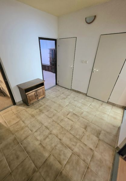 The interior of a 3-room apartment with a tiled floor and a wooden cabinet.