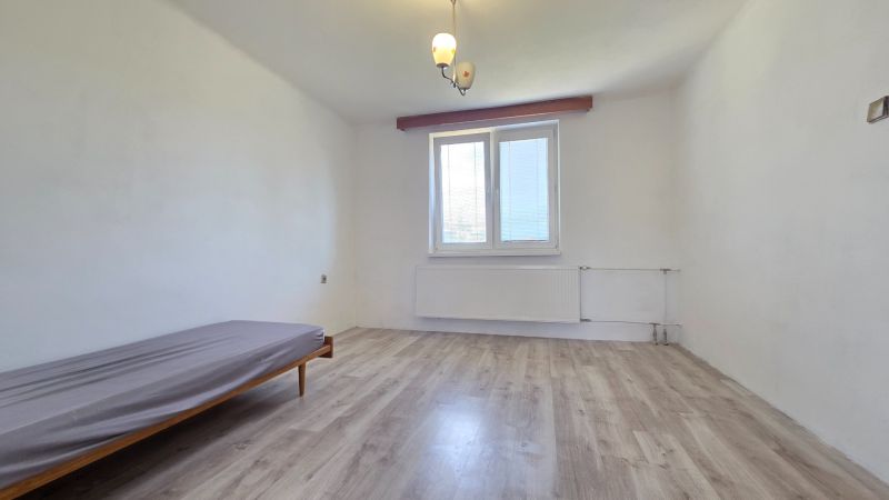 A room in a family house with a bed and a wooden decor floor.