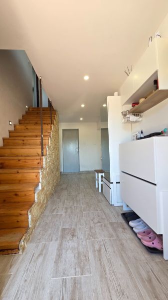 A hallway in a family house with a wooden staircase and a floor with a wooden decor.