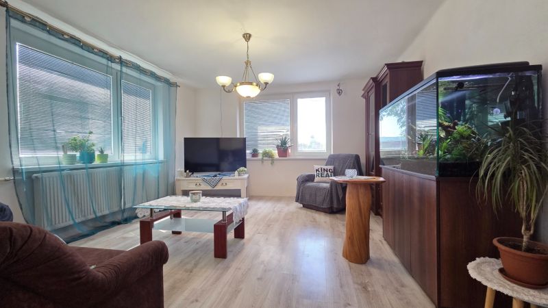Living room in a family house with an aquarium, television, and wooden decor flooring.