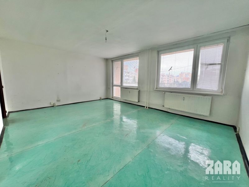 A spacious room in a 3-room apartment with radiators and large windows.
