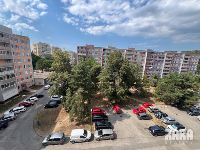 Apartment buildings on Družicová Street in Košice - Nad jazerom district, parking lot, trees.