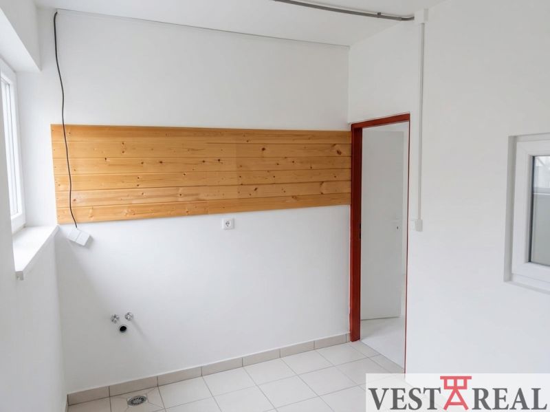 Interior with a wooden paneled wall and tiled floor, suitable for warehouses and halls.