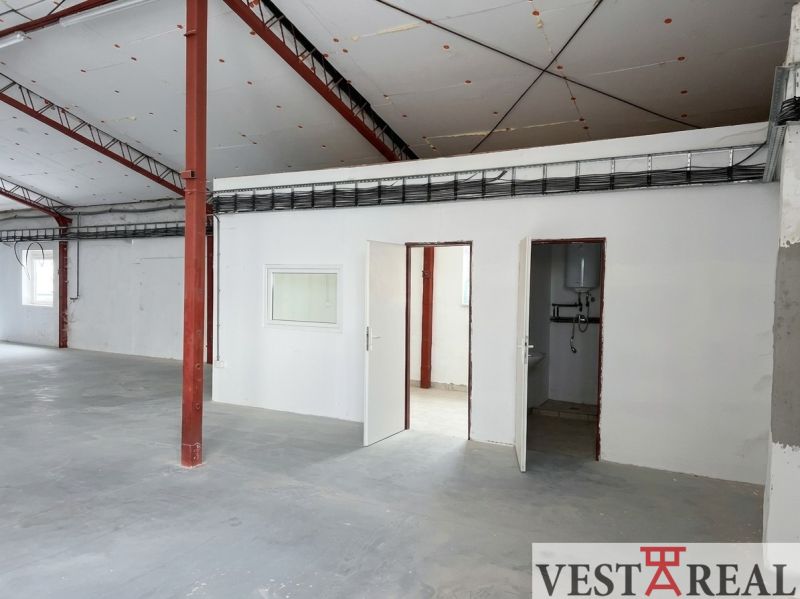 Interior of warehouses and halls with concrete floor, white wall, and metal structure.