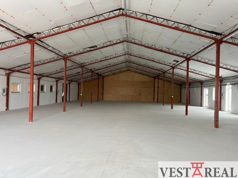 Warehouses and halls with iron beams, concrete floors, and wooden walls.