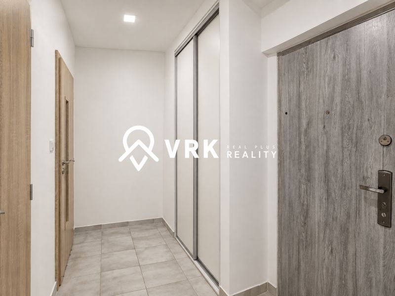Entrance hallway with tiles and wooden doors in a studio apartment.