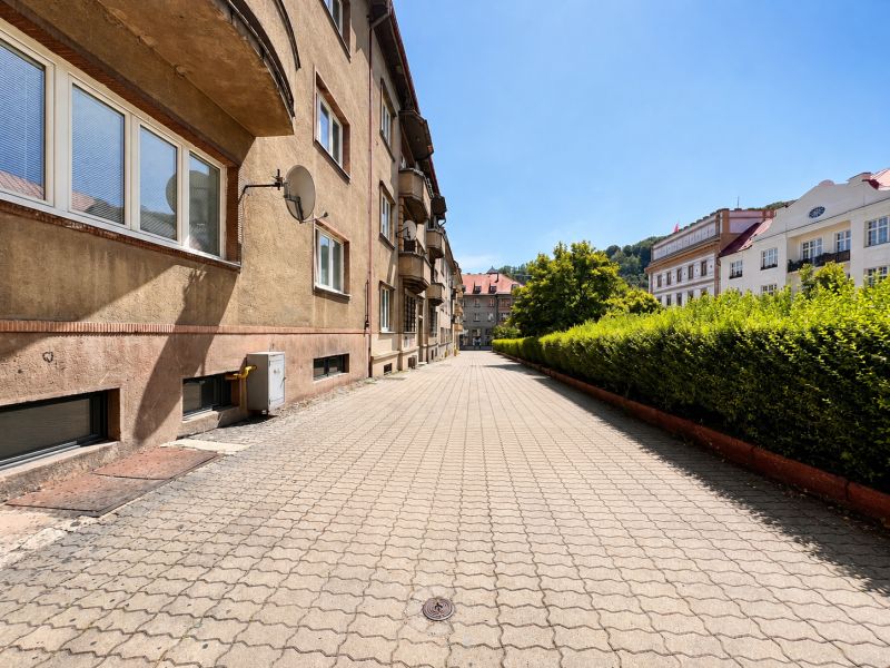 A city street with apartment buildings and a well-maintained sidewalk.