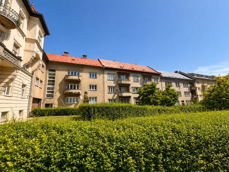 Apartment buildings with balconies and greenery on Národná Street in the city center.