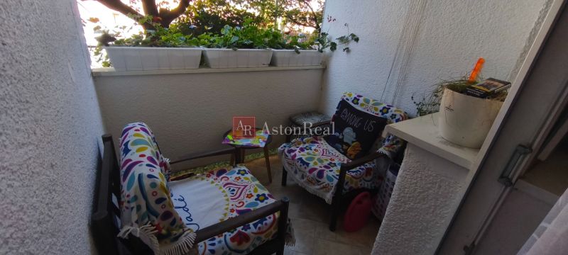 Balcony with colorful chairs and flowers, part of a 1-room apartment.