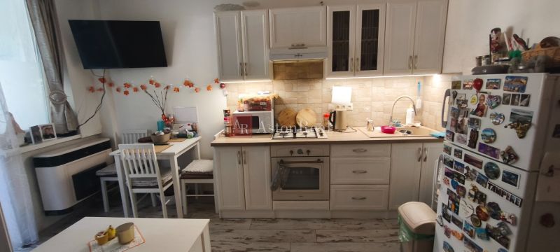 A kitchen with a dining table in a studio apartment, floor with wood decor.