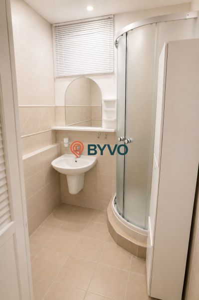Bathroom with a shower and a sink in a 3-room apartment with tiles.