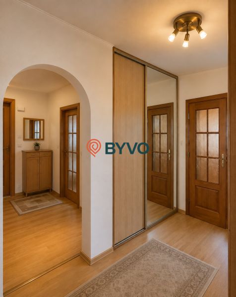 A hallway with a wooden decor floor and a built-in wardrobe in a 3-room apartment.
