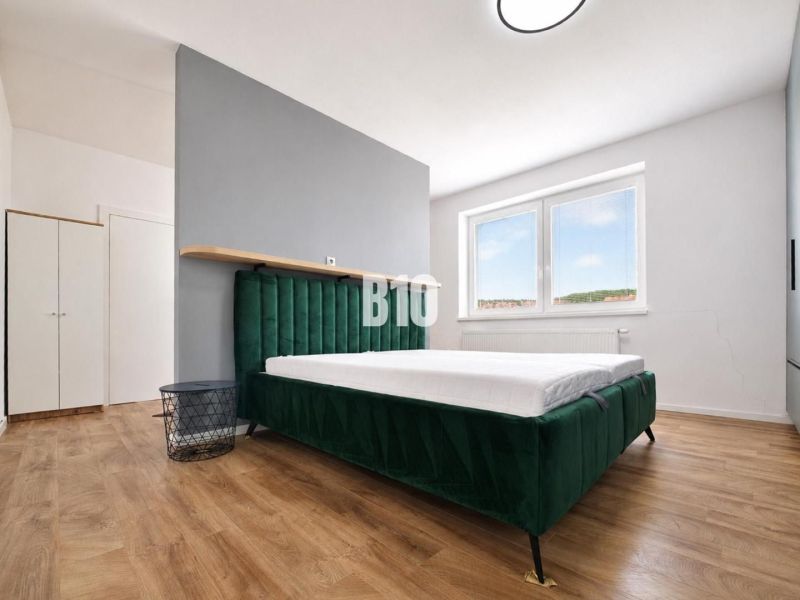 A bedroom in a holiday apartment with a bed and a wooden decor floor.