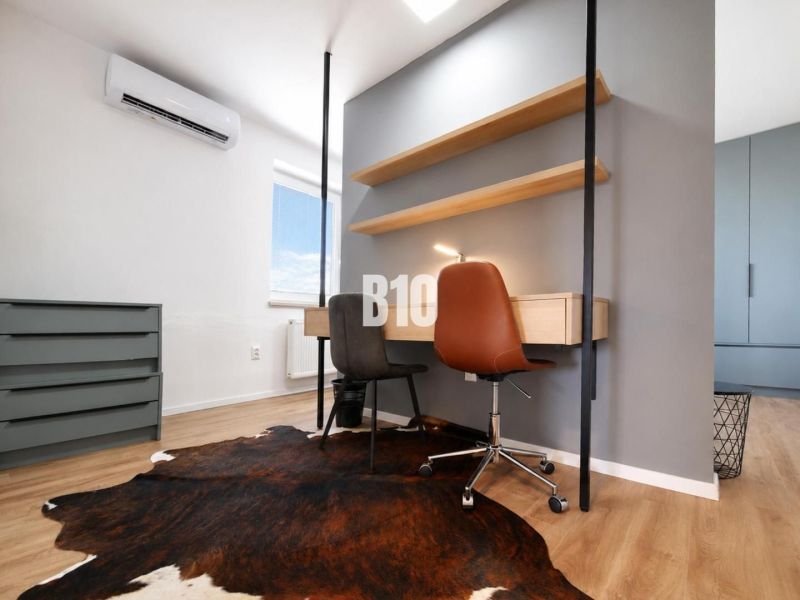 A work corner in a recreational apartment with a carpet touch and a wooden decor floor.