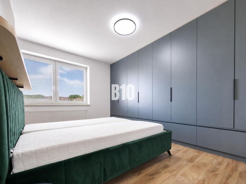 Bedroom in a holiday apartment with a comfortable bed and wooden decor flooring.