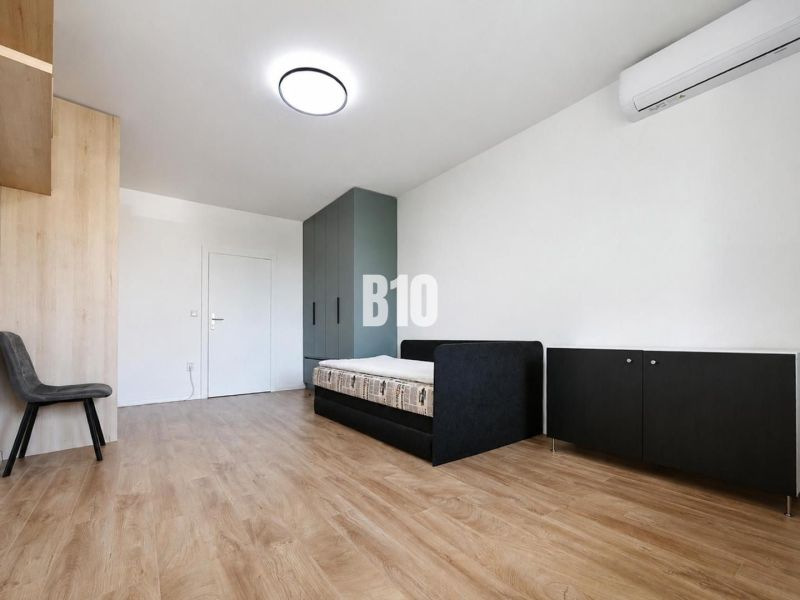 Recreational apartment with a bed, wardrobe, and wooden decor flooring.