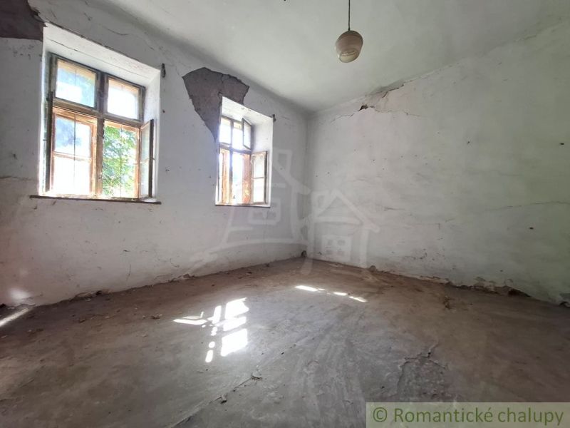Abandoned interior with damaged walls and two windows, Property - housing.