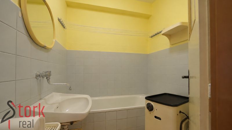 Bathroom with a bathtub and sink, colorful walls, three-room apartment.