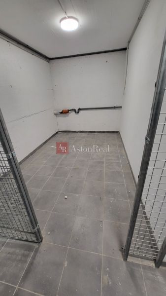 A cage-like cellar in the basement of a 3-room apartment, with brick walls and tiled floor.