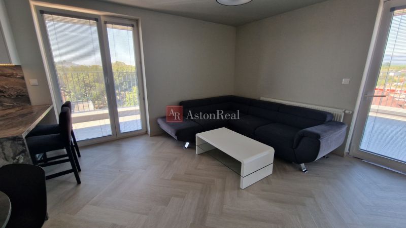 Living room with a corner sofa, coffee table, and floor with wood decor.