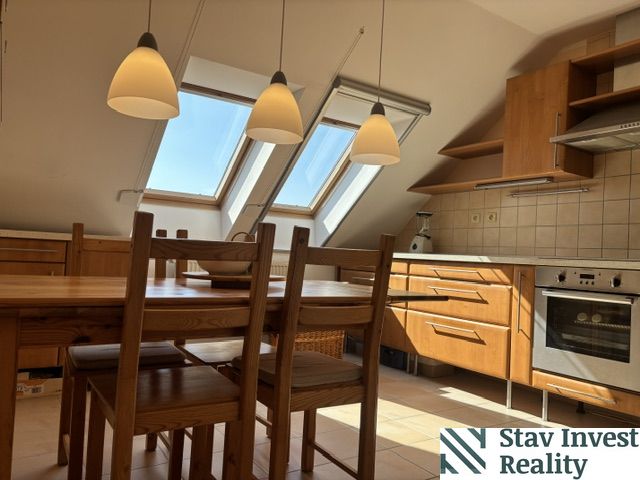 The kitchen area of a 4-room apartment with skylights and a floor with a wooden decor.