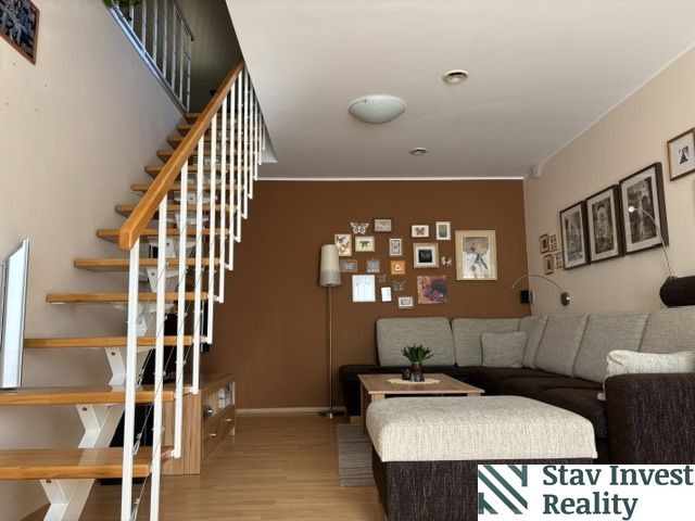 Living room of a 4-room apartment with a wooden decor floor and a staircase.