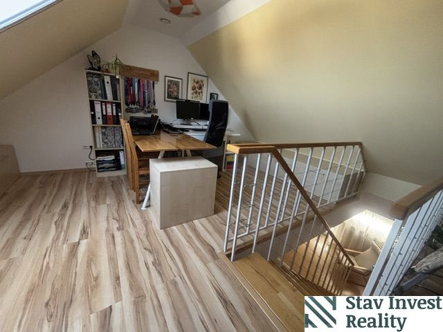 Attic office in a 4-room apartment with wood-patterned flooring and a desk.